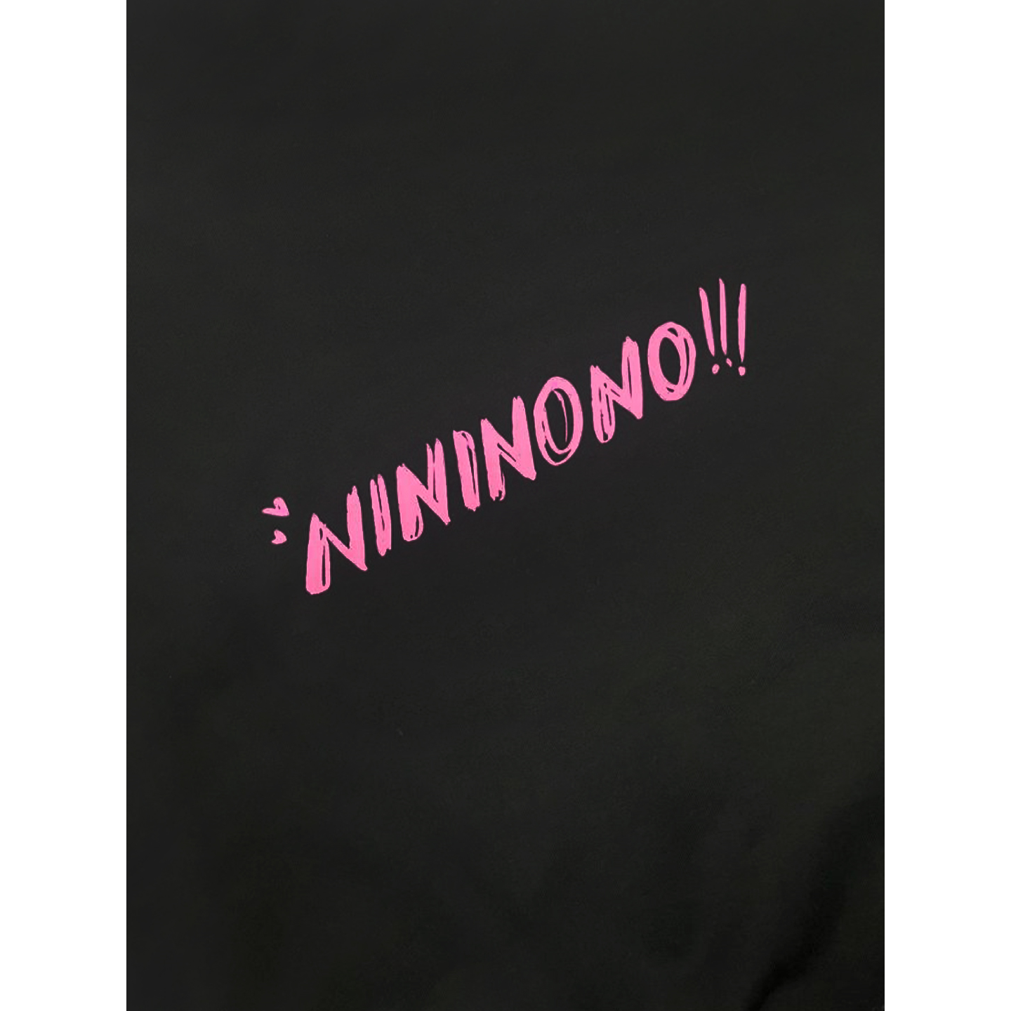 Close-up of the pink "NININONO!!!" branding printed on the upper back of the sweatshirt.