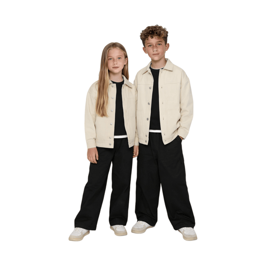 A boy and a girl wearing the ninø khaki vintage workwear denim jackets, showcasing the relaxed gender-neutral fit and modern minimalist styling.