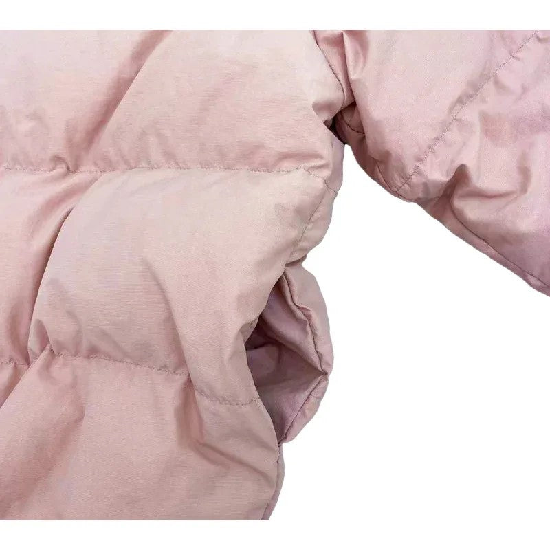 Detail shot of the ribbed windproof cuffs and the subtle nininono branding on the chest.