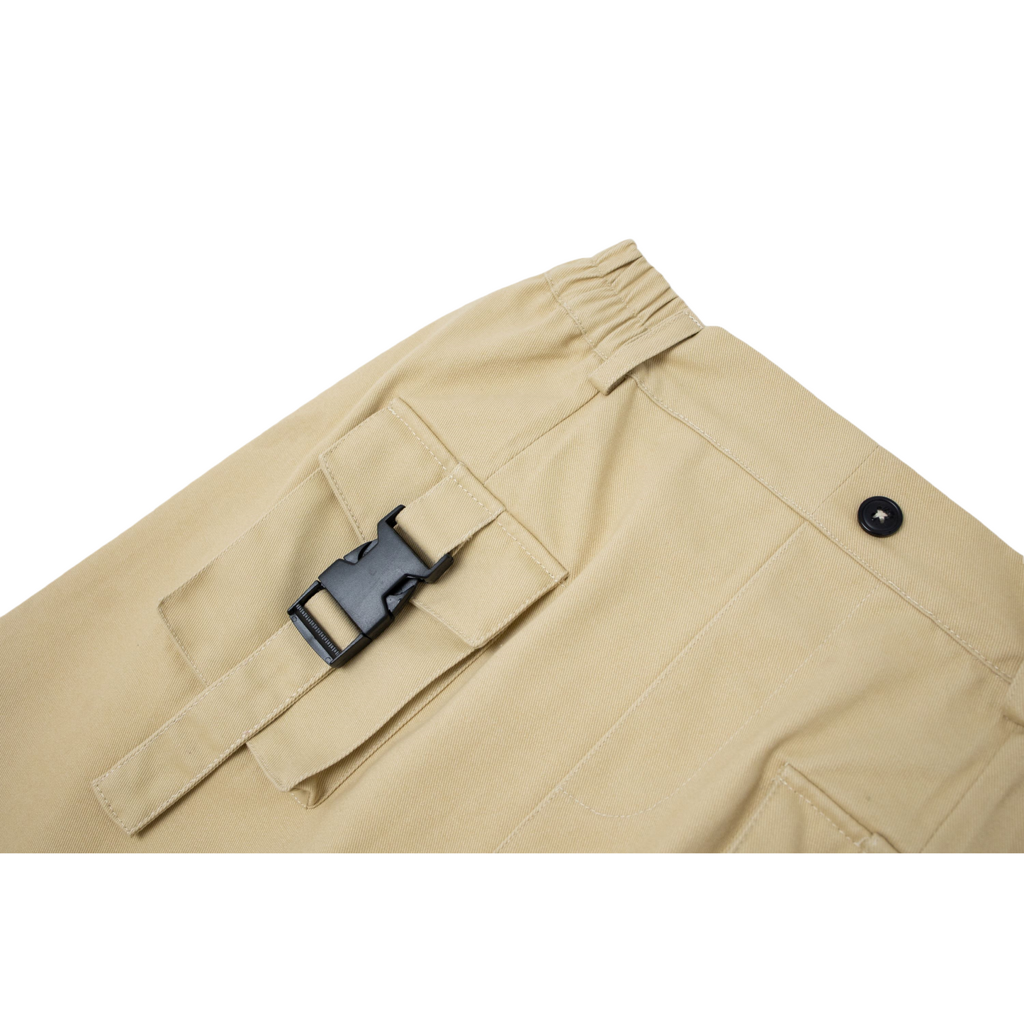 Close-up of the double-button cargo pocket with a black buckle strap and "nininono" logo detail.