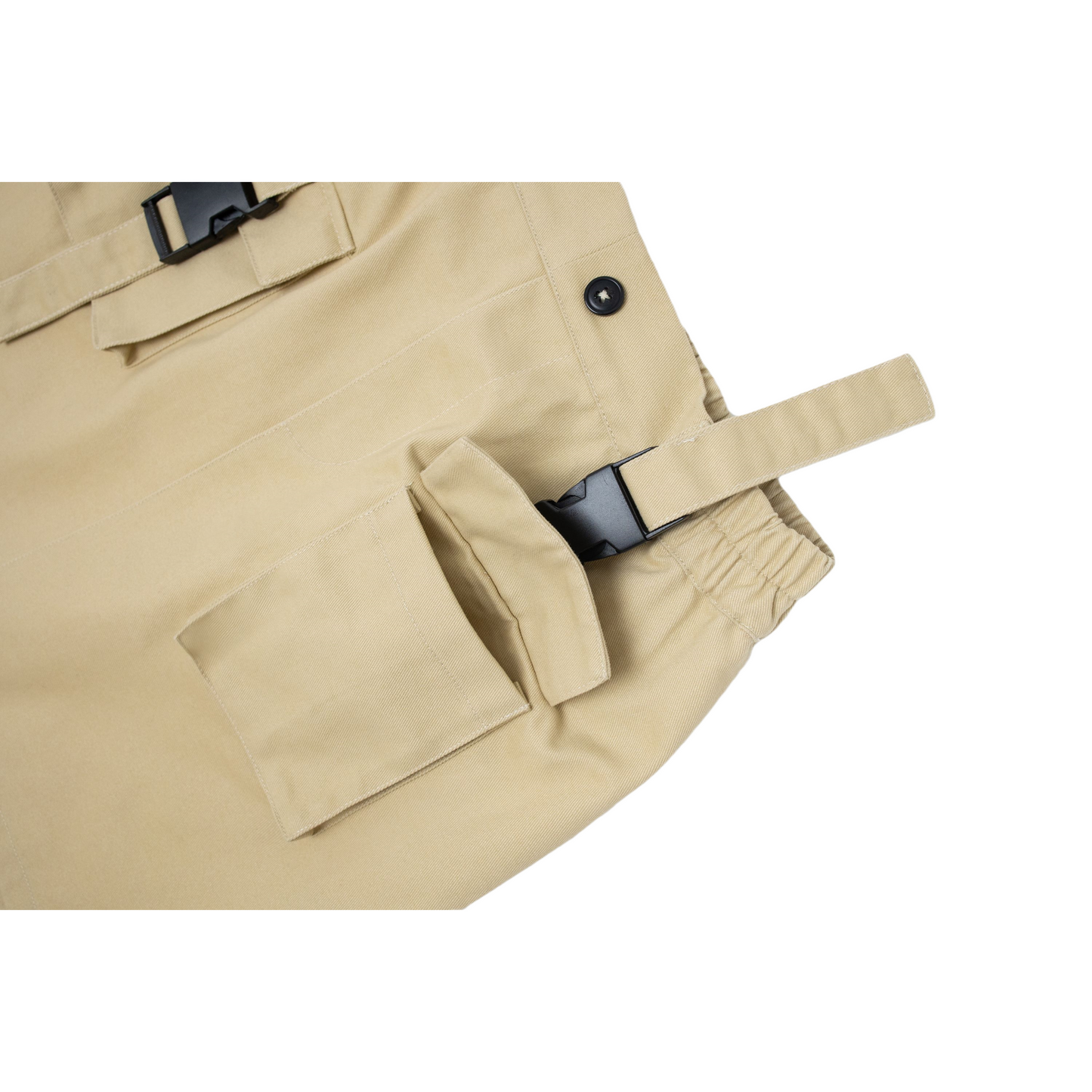 Close-up of the double-button cargo pocket with a black buckle strap and "nininono" logo detail.