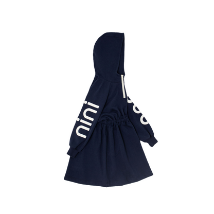Right side view of the navy hooded sweatshirt dress, showcasing the bold white "nini" graphic print along the sleeve and the structured half-zip hood profile.