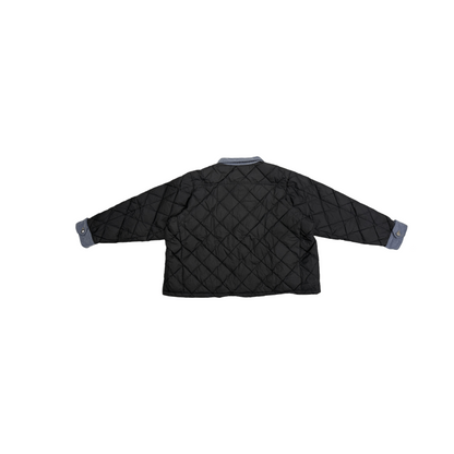 Back view of the black diamond-quilted jacket, highlighting the clean structural design and oversized silhouette.
