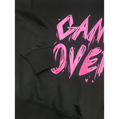 Close-up of the ribbed elasticated sleeve cuffs on the black ninø pullover, highlighting the high-quality stitching and durable cotton fabric next to the pink graphic print.