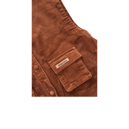 Close-up of the corduroy vest pocket highlighting the premium transparent silicone "nini&nono" label, meticulously sewn for a modern aesthetic.