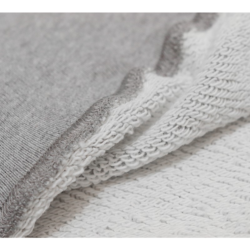 Close-up of the breathable 100% cotton fabric and the durable ribbed hem of the sweat vest.