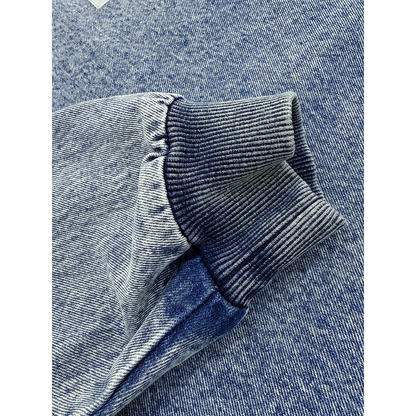 Close-up of the elasticated ribbed cuffs on the oversized denim pullover, highlighting the soft 100% cotton texture.