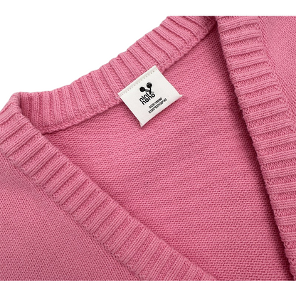 Close-up of the ribbed V-neckline and inner brand label on the pink knit sweater.