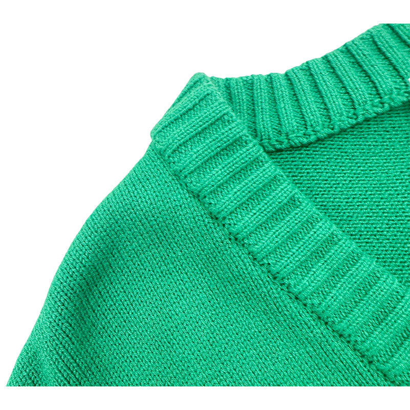 Close-up of the ribbed V-neckline and brand tag on the green knit sweater.