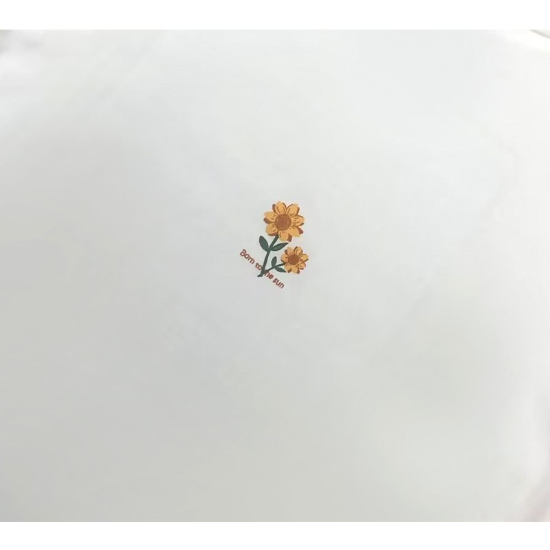 Detailed shot of the small, delicate sunflower graphic printed on the back of the neck.