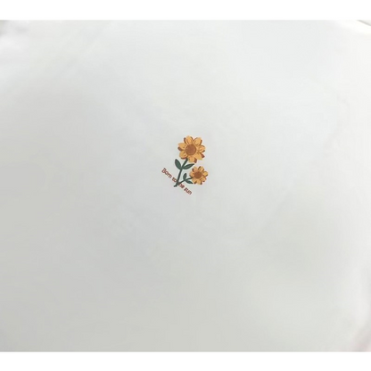 Detailed shot of the small, delicate sunflower graphic printed on the back of the neck.