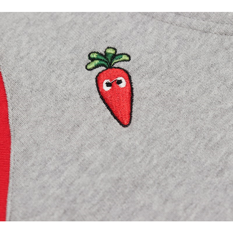 Detailed shot of the vibrant red and green carrot embroidery on the chest of the grey cotton vest.