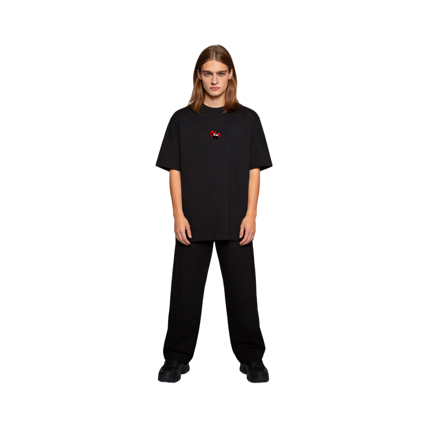 Close-up of a model wearing the ØGENDER black premium cotton tee featuring a small red ladybug graphic on the chest.