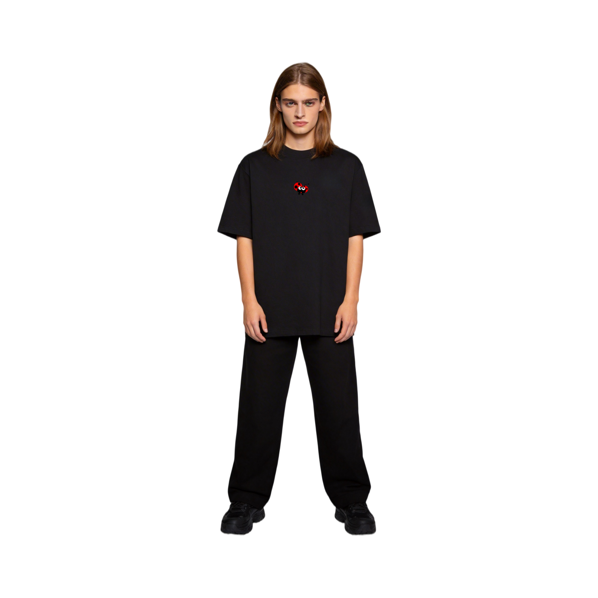 Close-up of a model wearing the ØGENDER black premium cotton tee featuring a small red ladybug graphic on the chest.