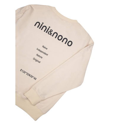 Detailed view of the sweatshirt's back featuring the signature "nini&nono" branding and the "Naive Independent Nature Original" text print with geographic coordinates.