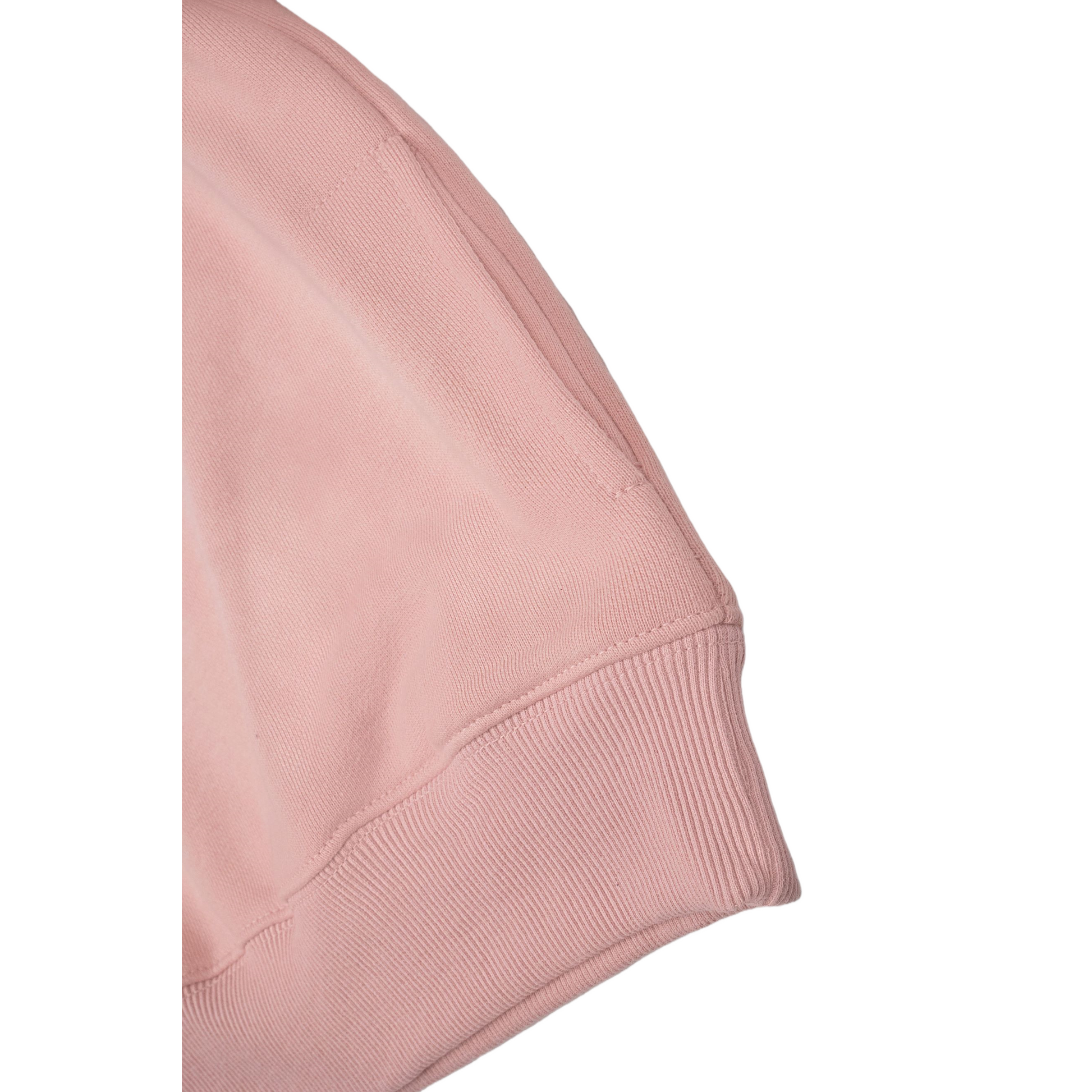 Close-up of the pink polo sweatshirt highlighting the discreet invisible side pocket and the durable ribbed hem for a secure fit.