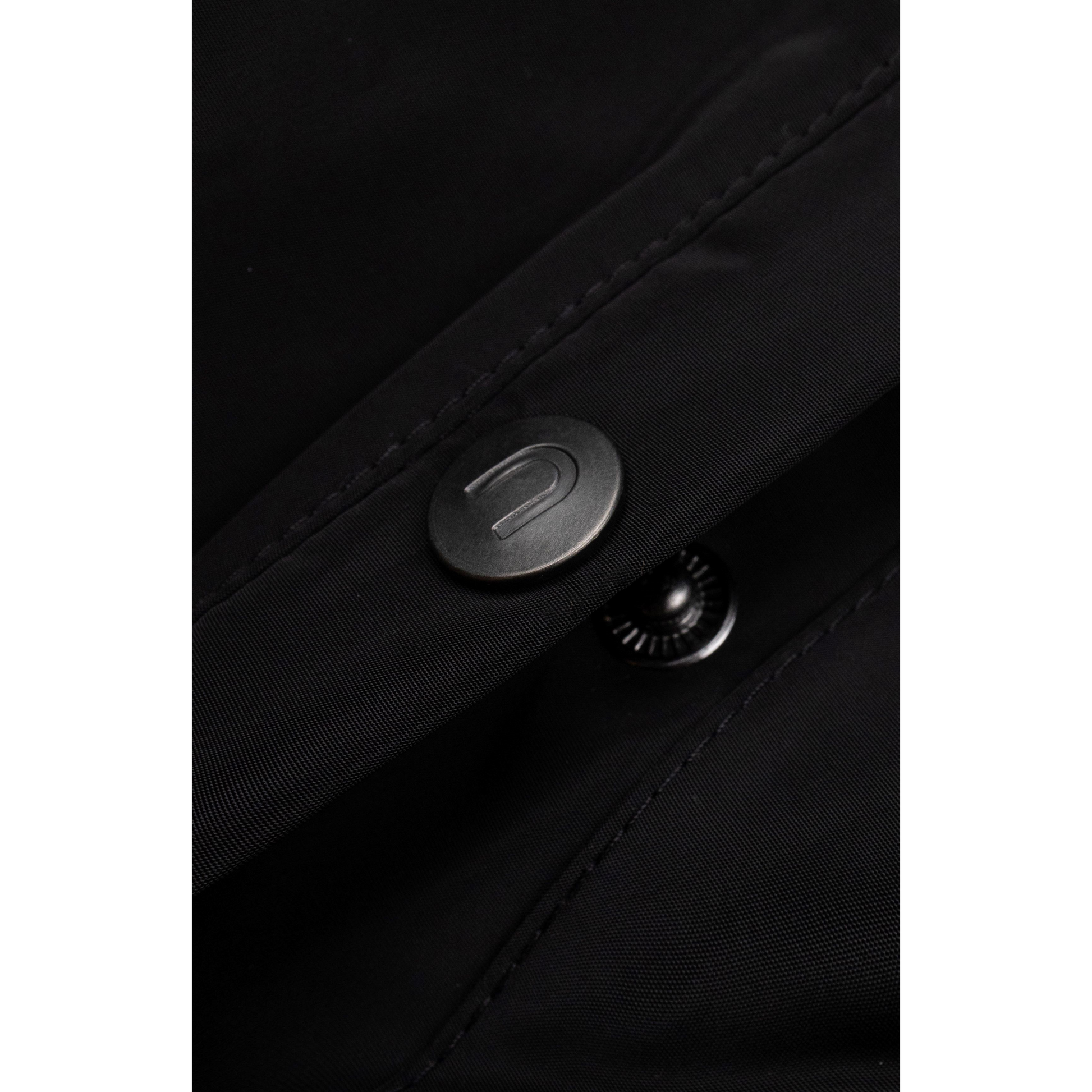 Detailed shot of the refined grey metal button on the durable water-resistant black fabric.