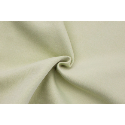 Extreme close-up of the soft 320g/m² Korean cotton fabric, showing the premium knit texture and vibrant avocado hue.