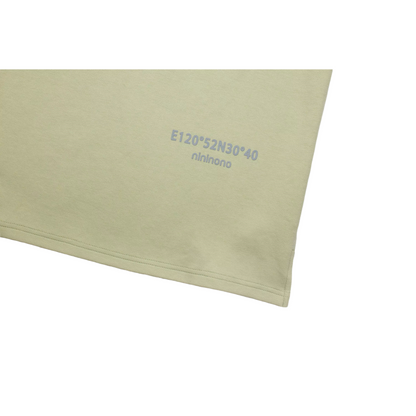 Detailed view of the high-density 3D silicone screen print featuring coordinates and the ninø brand name near the dress hem.