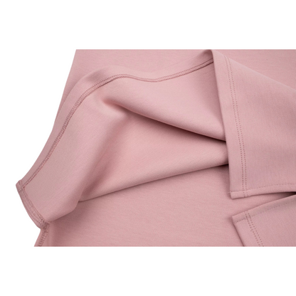 Close-up of the dress hem flipped over to reveal the meticulous interior stitching and high-quality seam finishing on the pink cotton fabric.