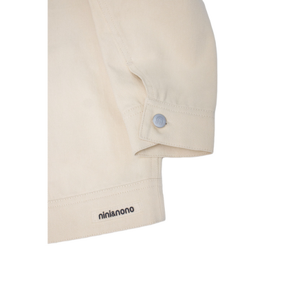 Detailed view of the back hem featuring the signature transparent silicone "nini&nono" logo patch, securely stitched for a premium industrial look.