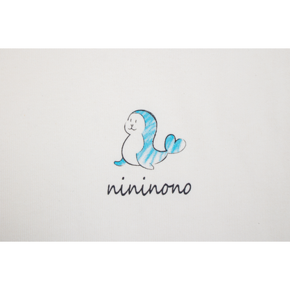 Close-up of the chest print featuring a playful dolphin graphic and the handwritten "nininono" brand name.