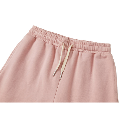 Close-up of the elastic waistband on the kids' cotton shorts, showing the durable gathered stitching and adjustable cream-white drawstrings with neat knotted ends.