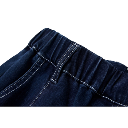 Close-up of the elasticated waistband and reinforced belt loops on dark blue denim.