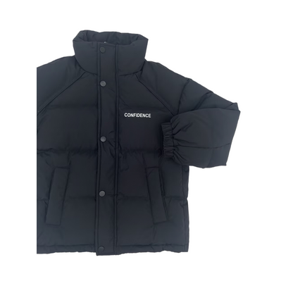 Detailed close-up of the black puffer jacket's chest area, showcasing the high-quality white "CONFIDENCE" typography and the structured stand-collar design.