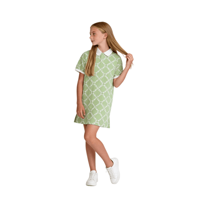 A young girl wearing the green all-over logo polo dress, demonstrating the comfortable knee-length fit and sporty A-line silhouette.