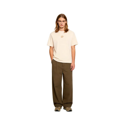 Full-body front view of a long-haired male model in Ogender cream 240 GSM 'Scarf Girl' art tee and dark khaki trousers. Highlights the minimalist front 'O' logo and relaxed unisex fit for teens and adults