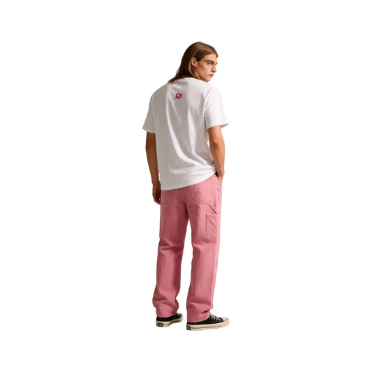 Side view of a long-haired male model in the Ogender white 240 GSM 'Music Tiger' tee and pink trousers. Displays the signature 'O' logo on the back neck and the relaxed oversized silhouette