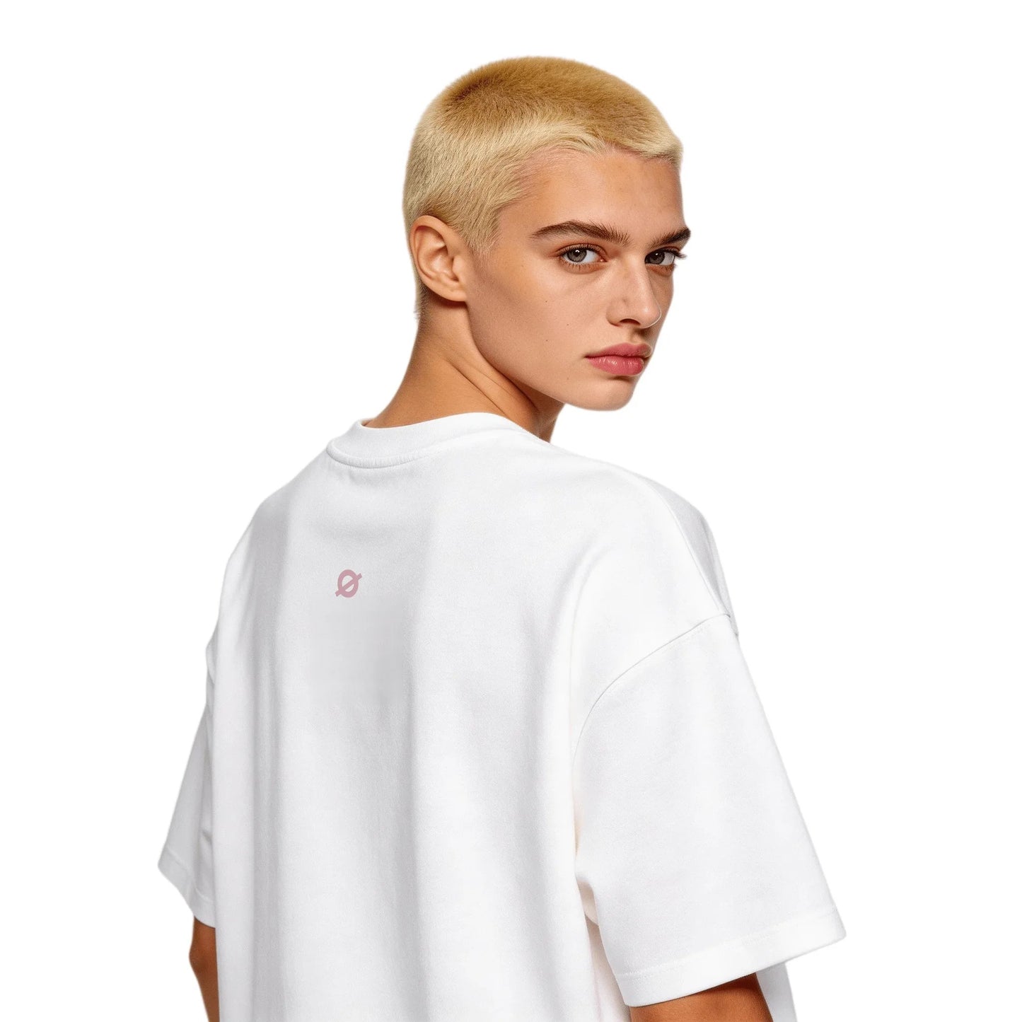 Back view of a young female model with blonde buzz cut wearing Ogender white oversized tee, highlighting the pink 'O' emblem on the neck.