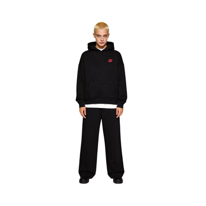Full-body front view of a buzz-cut female model wearing the Ogender black 350 GSM Garden Series hoodie. Showcases the signature 'O' logo on the left chest and the relaxed oversized streetwear fit