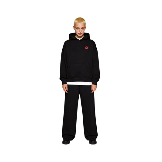 Full-body front view of a buzz-cut female model wearing the Ogender black 350 GSM Garden Series hoodie. Showcases the signature 'O' logo on the left chest and the relaxed oversized streetwear fit