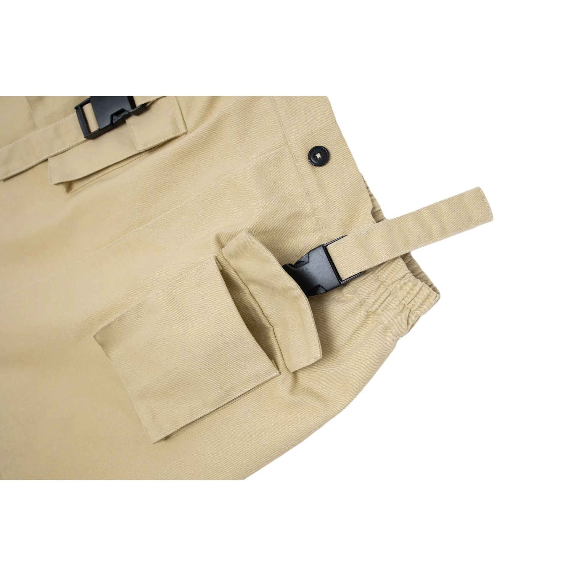 Close-up showing the hidden pocket opening underneath the decorative buckle flap on the khaki skirt.