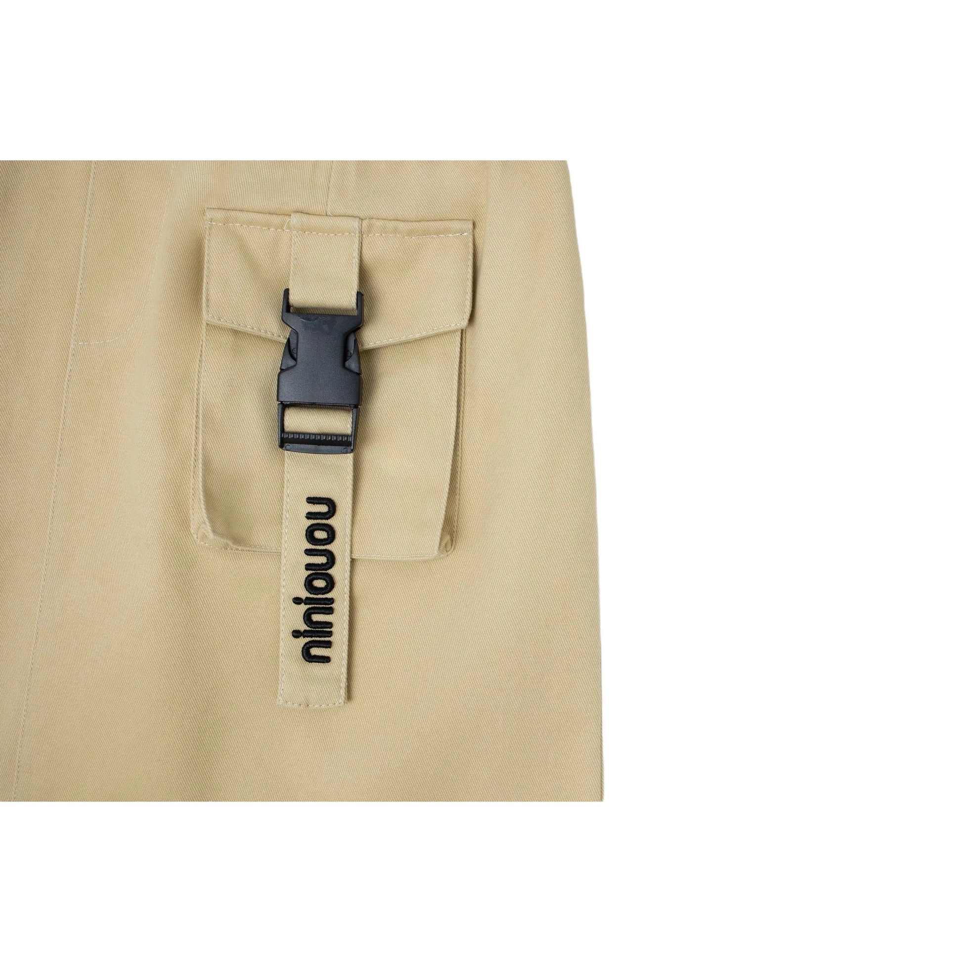 Close-up of the front cargo pocket featuring a quick-release black buckle strap and branding.