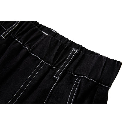 Close-up of the elasticated waistband and reinforced white contrast stitching on black denim.