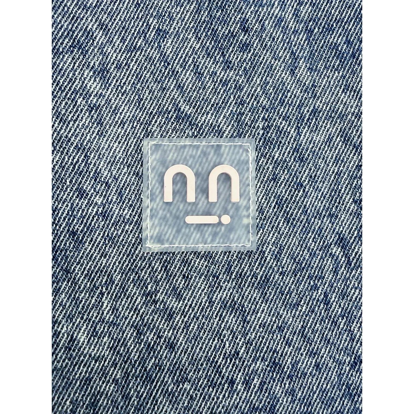 Close-up of the transparent silicone smiley patch precision-stitched on the chest