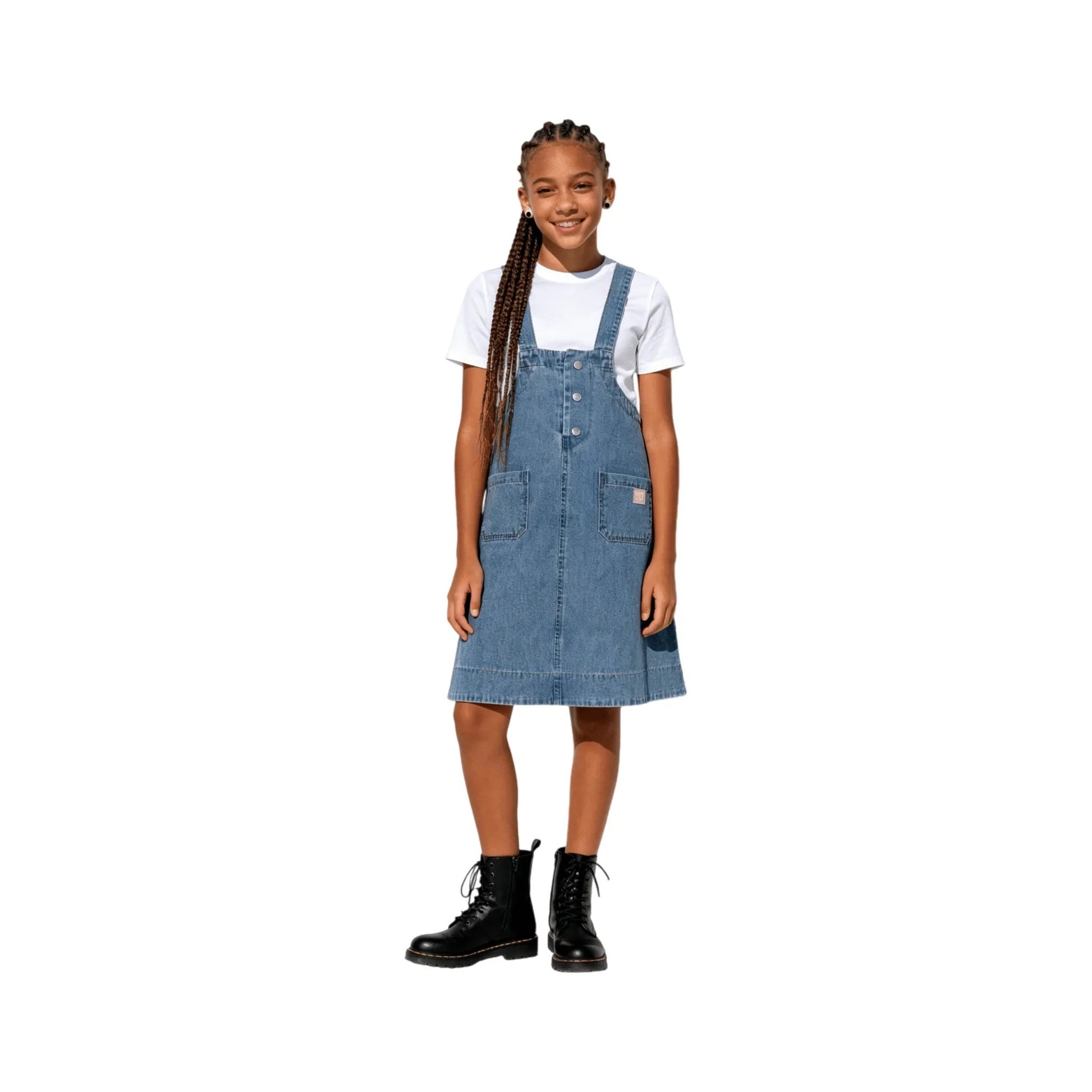 A young girl modeling the indigo denim pinafore dress, showing the waist pocket placement.