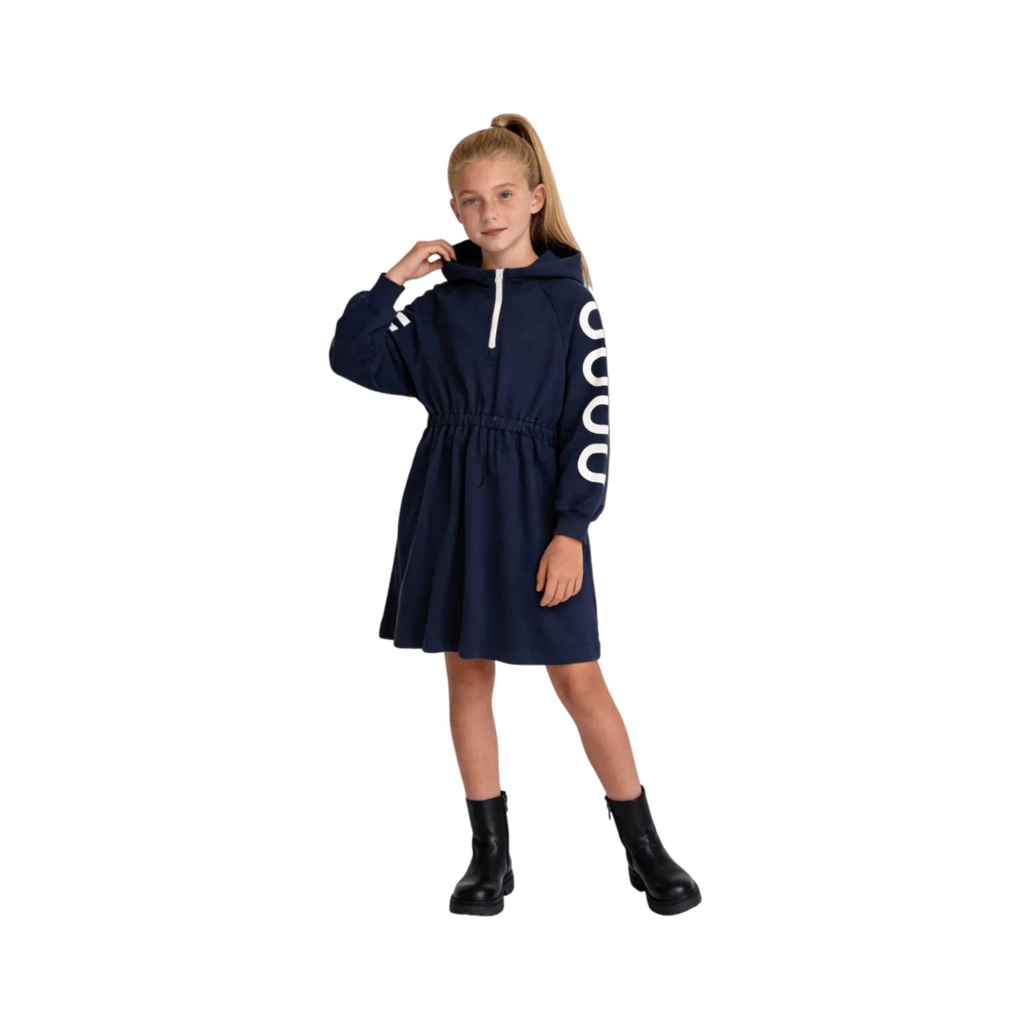 A girl modeling the navy hooded sweatshirt dress with black boots.
