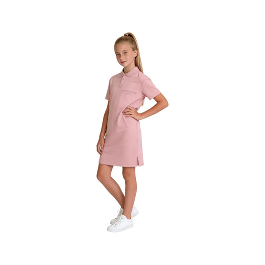 A girl modeling the pink A-line polo dress with white sneakers.