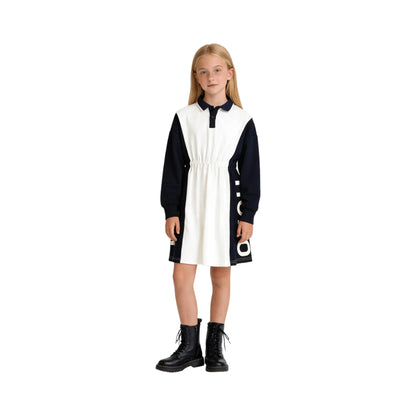 A young girl modeling the navy and white color-block polo dress, front view.