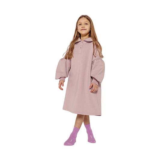 Girl modeling the Taro Purple polo dress, highlighting the crisp silhouette and puff sleeves.
