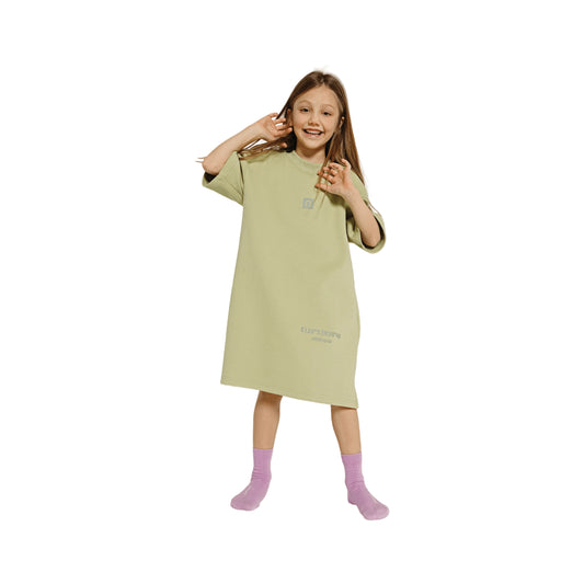 A young girl modeling the avocado green sweatshirt dress with purple socks.