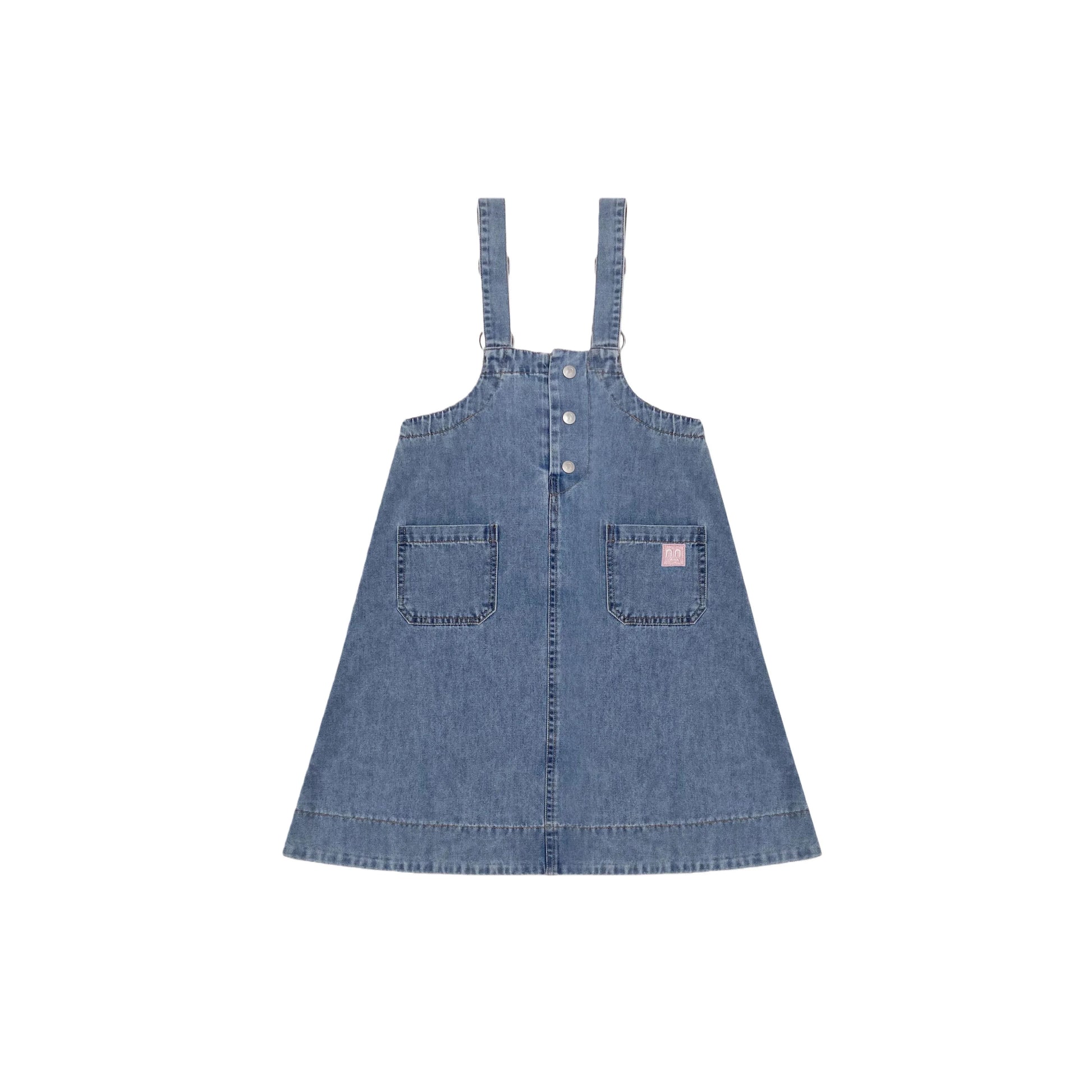 Front view of the indigo denim pinafore dress with side pockets and pink smiley detail.