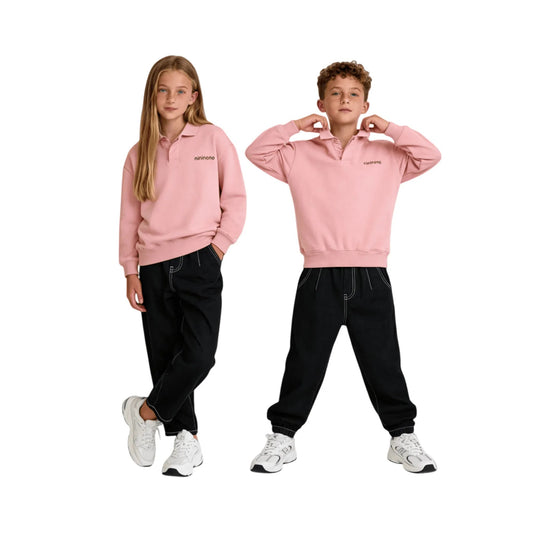 Boy and girl models wearing black carrot fit jeans and soft pink hoodies.