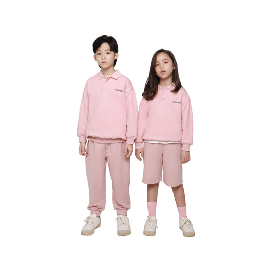 Two junior models wearing Ogender pink oversized polo sweatshirts and matching sweatpants, showcasing gender-neutral style.