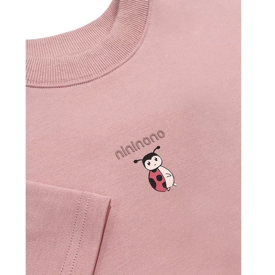 etailed shot of the hand-drawn ladybird graphic on the pink fabric.