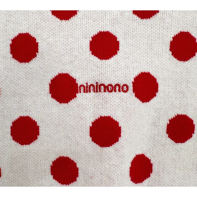 Detailed shot of the red nininono logo embroidery on the back of the cardigan.